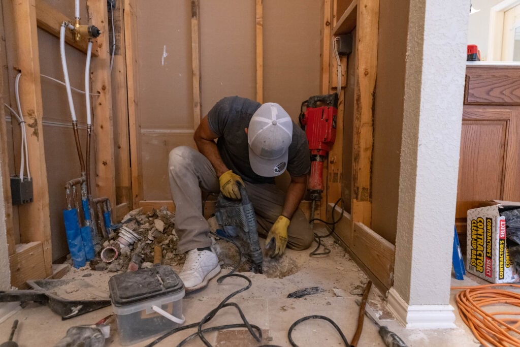 Photo of a ZINTEX bathroom remodeler working on the plumbing for a new shower
