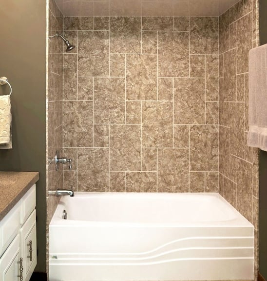 Photo of an acrylic tub and shower combination with faux-tile acrylic patterned walls