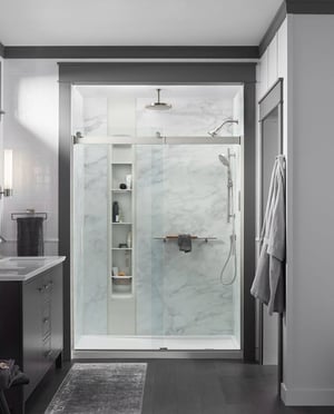 Photo of a luxury walk in shower with faux marble walls and built in storage