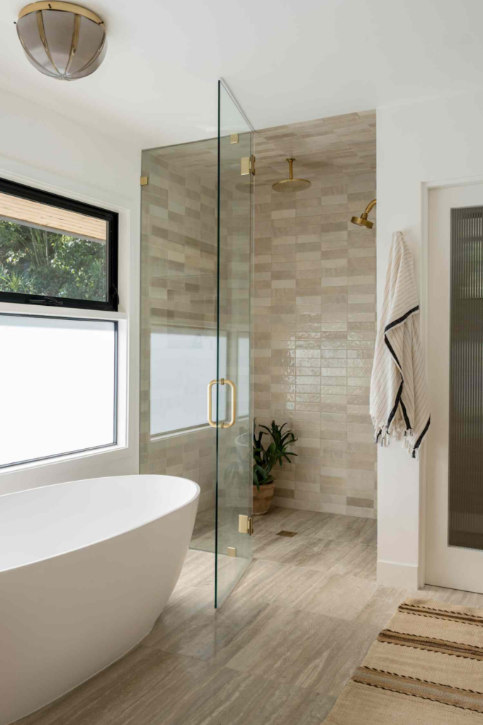 Photo of a luxurious bathroom with a stand-alone tub and a glass partition to a walk in shower
