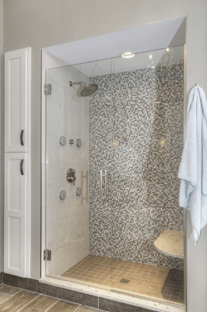 Photo of a walk in shower with patterned acrylic walls and a built-in seat.