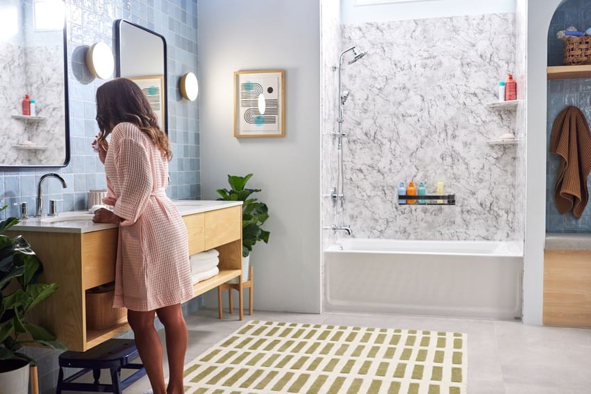 Photo of a woman standing in front of the vanity in a spacious bathroom with a Jacuzzi tub and shower combo